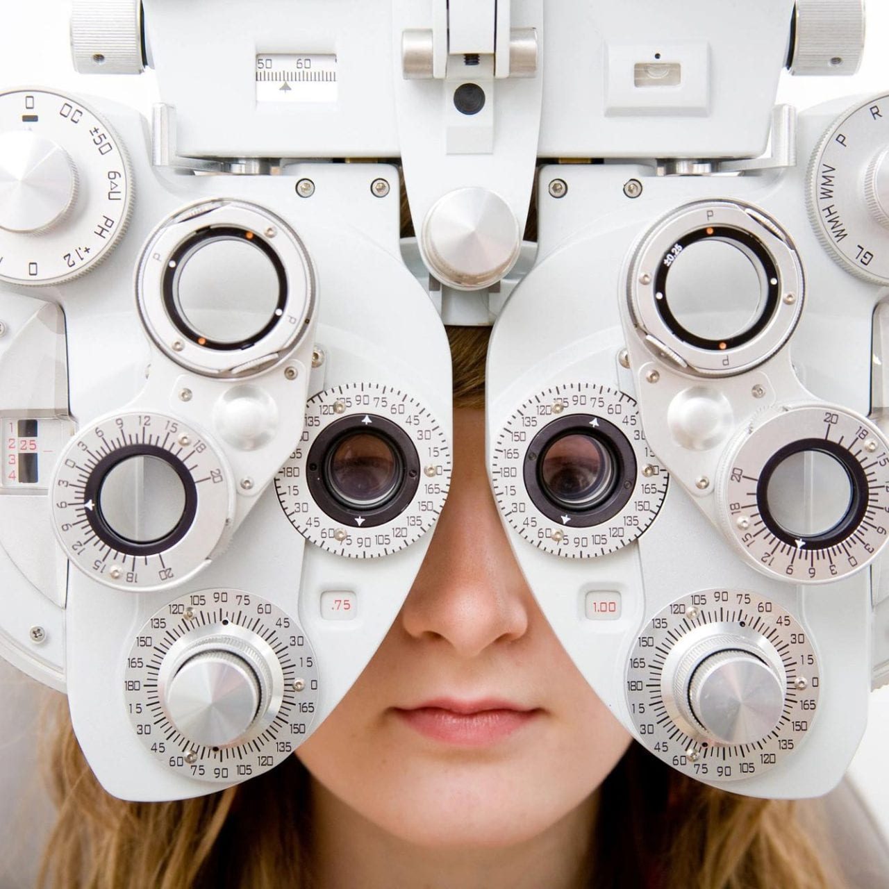 Person using a phoropter for eye exam.
